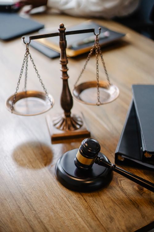 Mazo de juez junto a una balanza de justicia sobre un escritorio