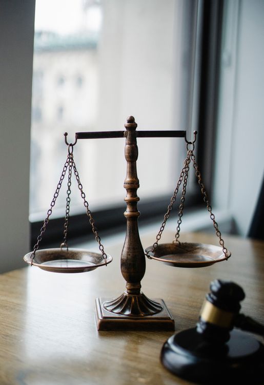 Balanza de la justicia y mazo judicial sobre el escritorio de una oficina de juez